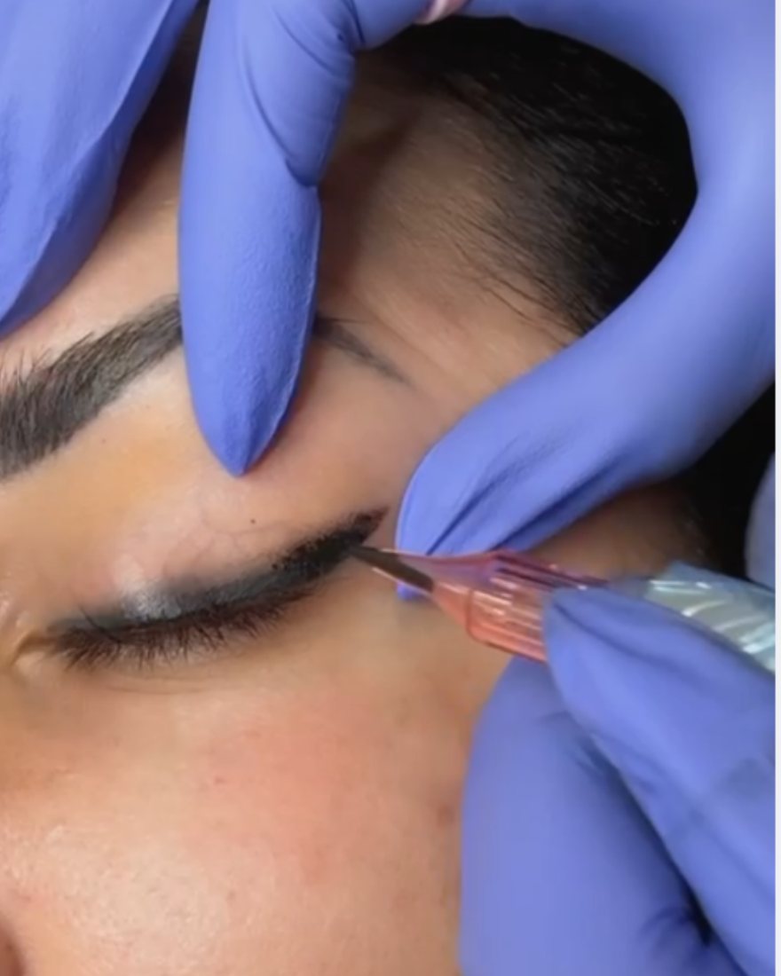 Angela applying permanent eyeliner during a session